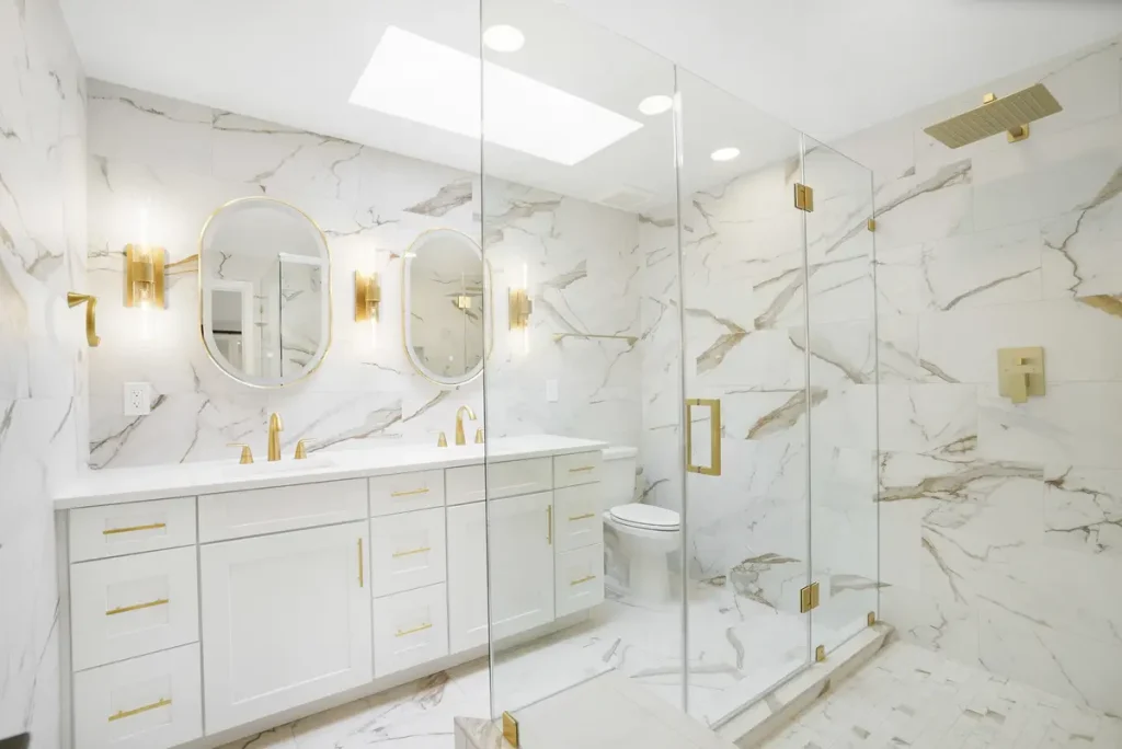 Modern marble bathroom with white double vanity and gold fixtures