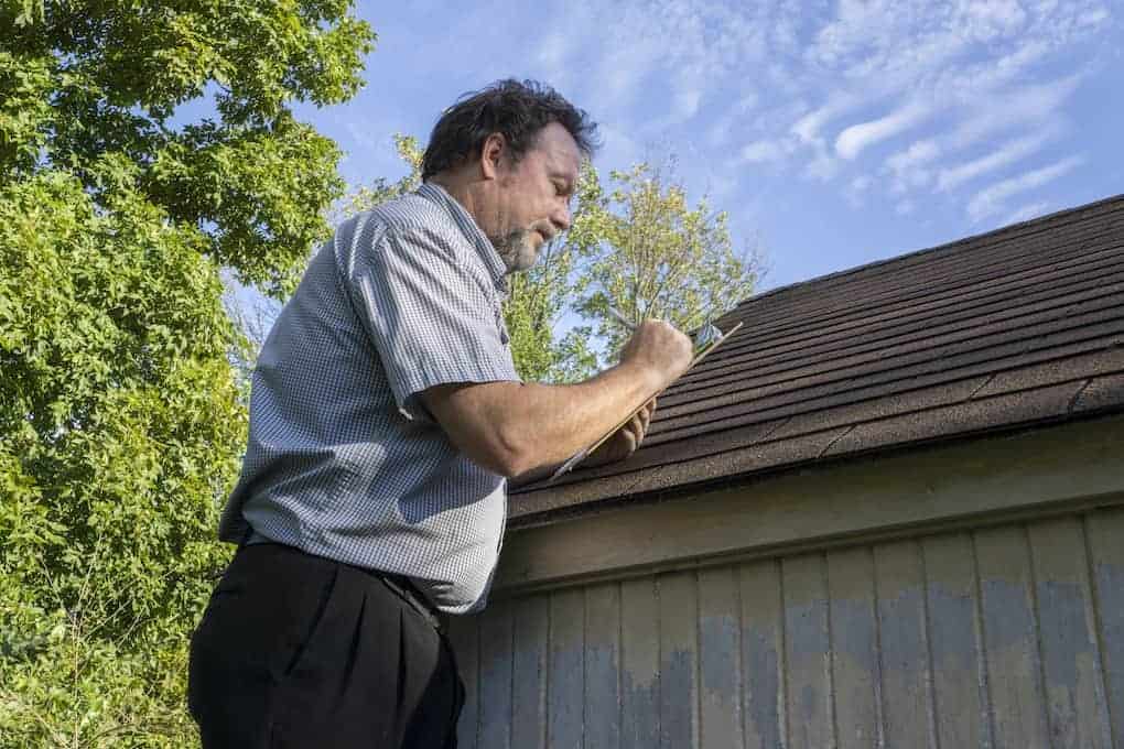 man giving roof inspection; how to get insurance to pay for roof replacement